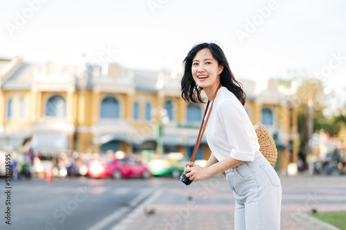 Portrait beautiful asian woman traveler with camera explore street on summer vacation in Bangkok, Thailand