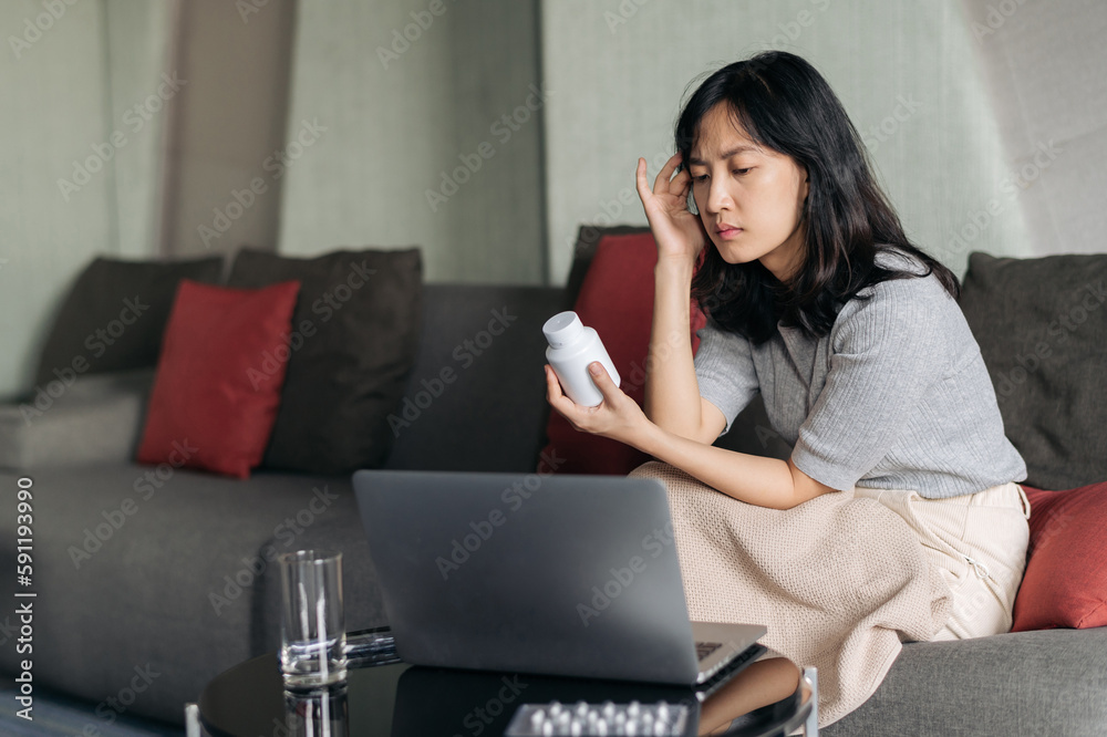 Sick asian woman with medicine having video call conference medical app in telehealth on laptop. Healthcare, technology and people concept Sick asian woman with medicine having video call conference medical app in telehealth on laptop. Healthcare, technology and people concept