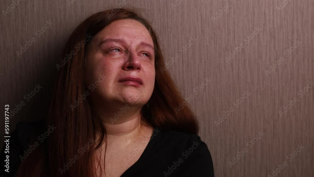 Upset woman bitterly cry looking up near room wall. Tears roll down cheeks, tearful eyes and swollen face. Splash out emotions, sob violently. Emotional breakdown, stress. Depression and hysterics.