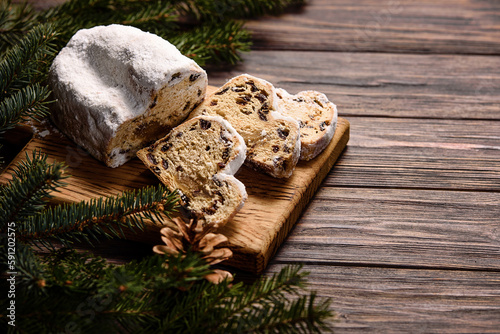 Christmas stollen on wooden background. Traditional christmas german dessert cut into pieces. Cake with nuts, raisins with marzipan and dried fruit on cutting board. baking for xmas