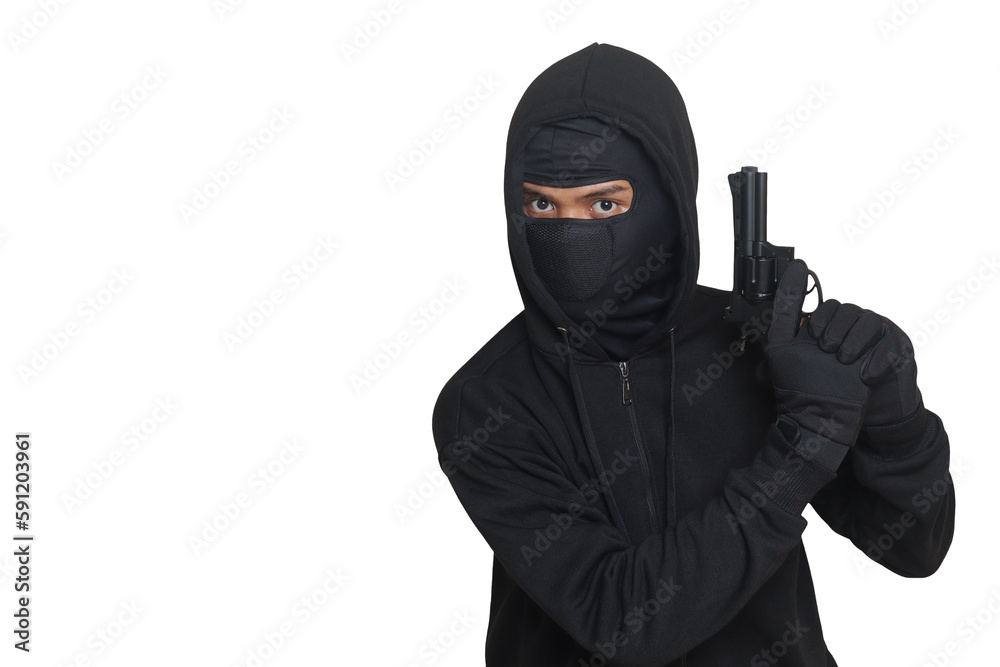Mysterious man wearing black hoodie and mask holding a pistol, shooting with a gun. Isolated image on gray background Mysterious man wearing black hoodie and mask holding a pistol, shooting with a gun. Isolated image on gray background
