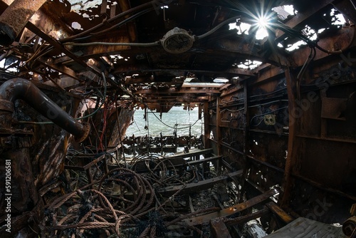 Rusted trawler shipwreck interior sun flare