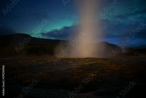 Geyser erupting in front of Aurora borealis  Geysir Iceland