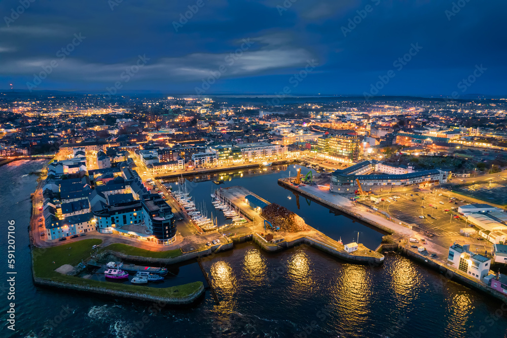 Illuminated port town at night. Aerial view on River Corrib and Galway ...
