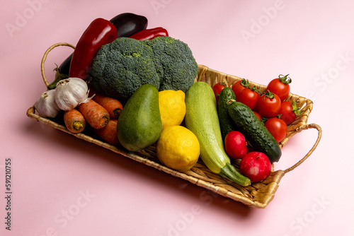 Fototapeta Naklejka Na Ścianę i Meble -  Vegetables in a basket. Wicker basket with assorted raw organic vegetables in the garden.