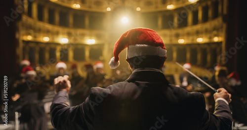 Cinematic Back View of Conductor Directing Symphony Orchestra with Performers All Wearing Santa Hats Playing Instruments on Classic Theatre with Curtain Stage During Christmas Music Concert