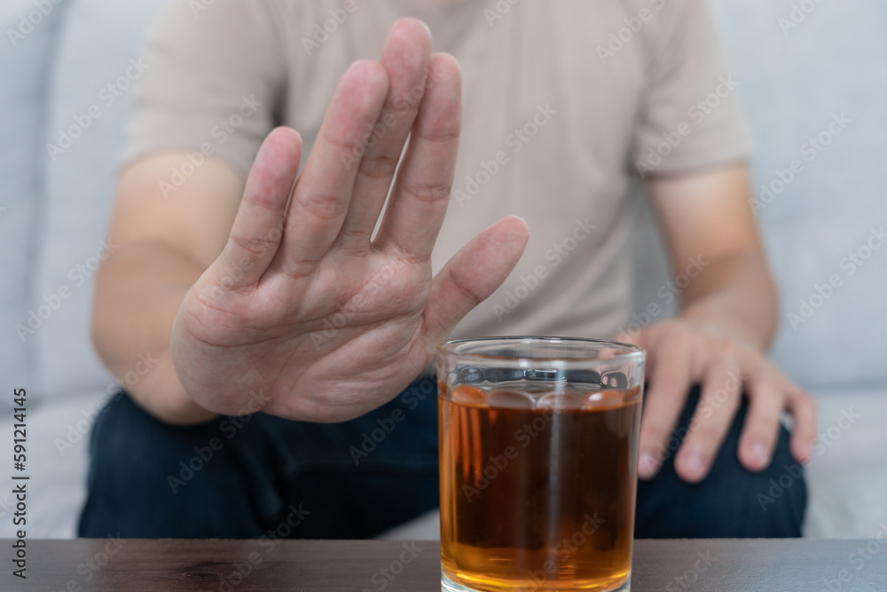 man refuses say no and avoid to drink an alcohol whiskey , stopping