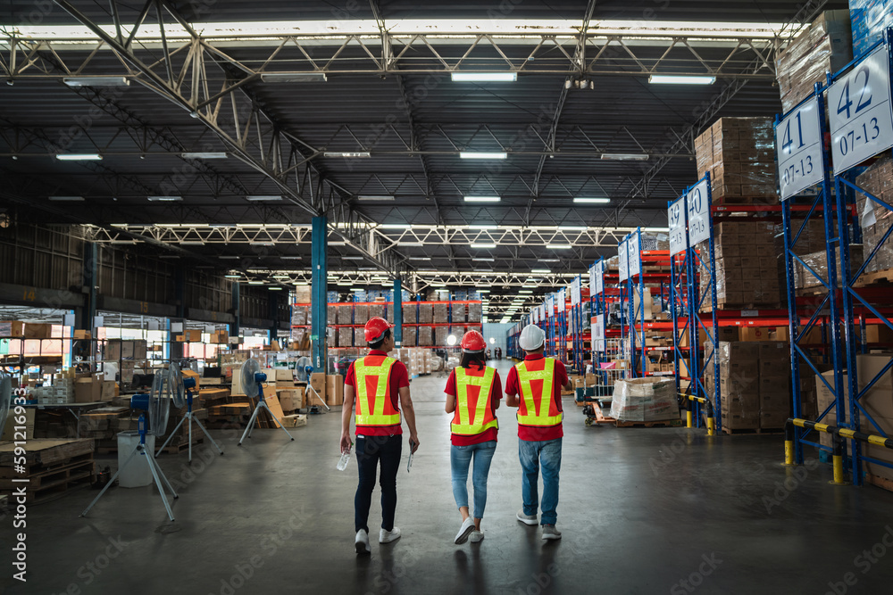Warehouse workers walking to check details stock product in the background warehouse., Industrial and industrial concept..