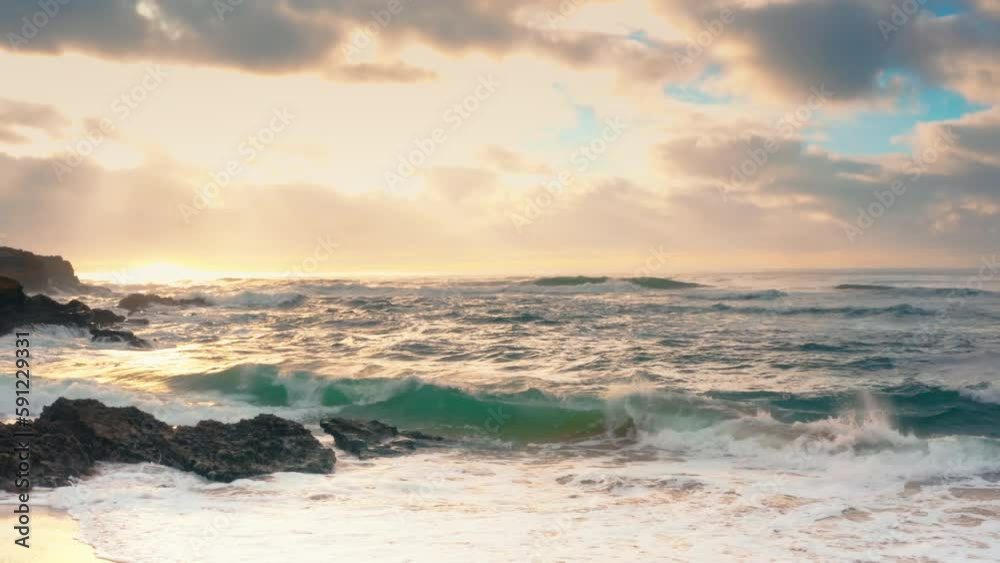 Ocean after storm on sunset time. Ocean waves in the evening at sunset with bright sun light and cloudy sky Ocean after storm on sunset time. Ocean waves in the evening at sunset with bright sun light and cloudy sky