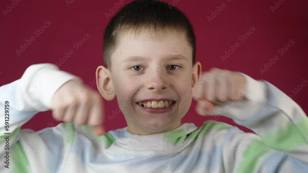 confident european boy 9 years old looks at the camera and punches and