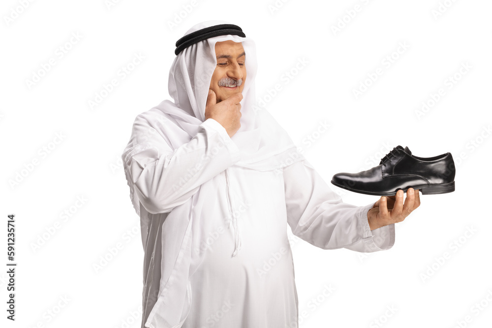 Arab man holding a black leather shoe and thinking Arab man holding a black leather shoe and thinking