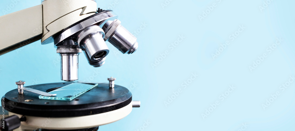 Microscope close-up on a blue background. Banner, Side view, place for text