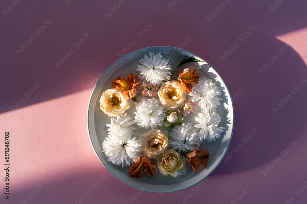 Beautiful composition of buds of various summer flowers. Top view of flowers on a pink background