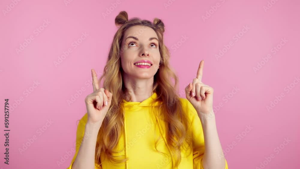 Woman and pointing at mockup workspace for advertisement, marketing, promotion or text. Female model happy smiling showing mock up for news deal of offer in studio on pink background Woman and pointing at mockup workspace for advertisement, marketing, promotion or text. Female model happy smiling showing mock up for news deal of offer in studio on pink background