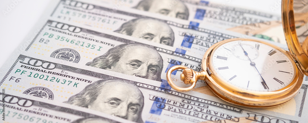 Macro shot of pocket watch face with 100 dollar bill Ben Franklinmoney and time concept - old pocket watch on pile of american bill dollars Macro shot of pocket watch face with 100 dollar bill Ben Franklinmoney and time concept - old pocket watch on pile of american bill dollars