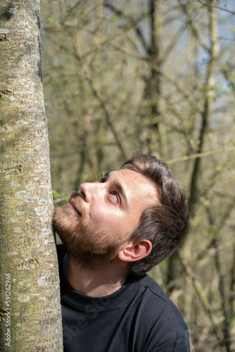 Jeune homme regardant le haut d'un arbre
