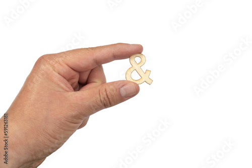 An unrecognizable person holding an Ampersand symbol against a white background. Conjunction sign.