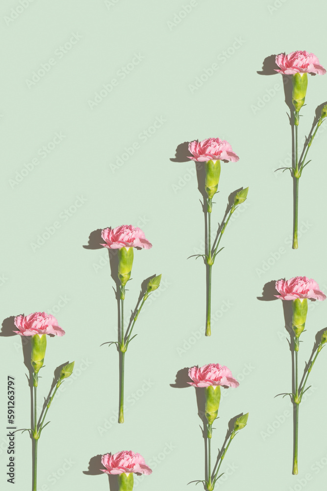Pink carnation pattern on a green background with copy space