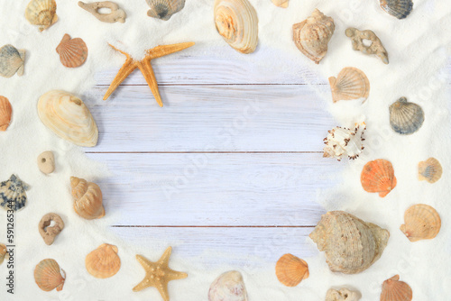 Top view of a light wooden background with sand, shells and starfish. Summer composition, board background and sand. The concept of summer vacation, and resort