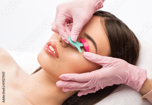 Make-up artist makes the procedure of lamination and dyeing of eyelashes to a beautiful woman in a beauty salon. Eyelash extensions. Eyelashes close-up