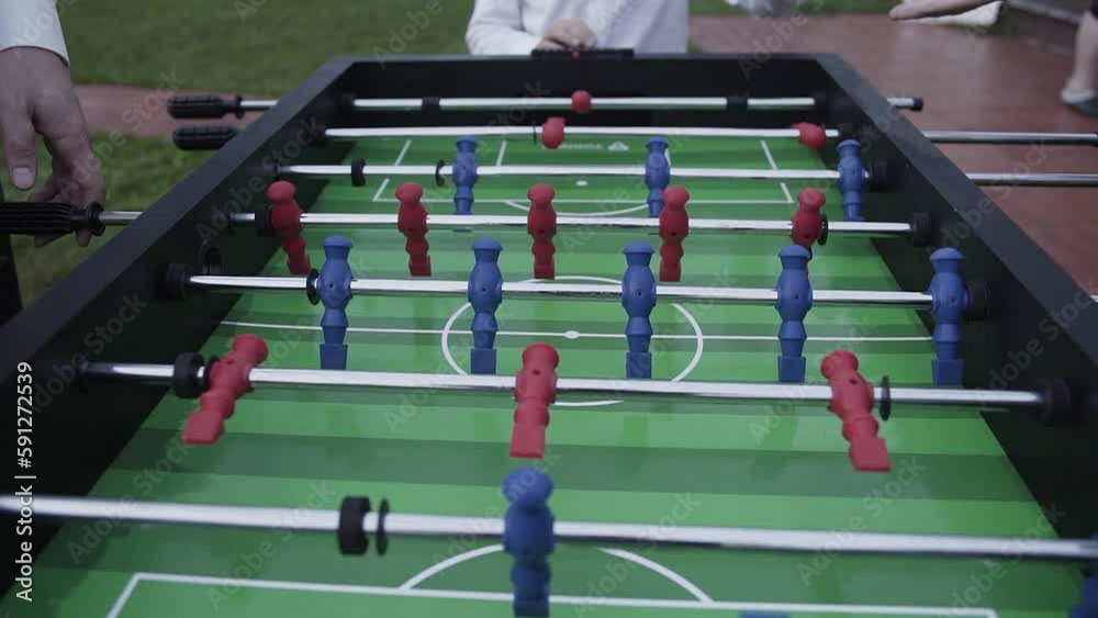 People play table football outdoors People play table football outdoors