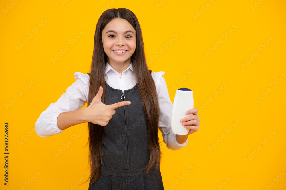 Teenager child girl showing bottle shampoo conditioners or shower gel. Hair cosmetic product. Bottle for advertising mock up copy space. Teenager child girl showing bottle shampoo conditioners or shower gel. Hair cosmetic product. Bottle for advertising mock up copy space.