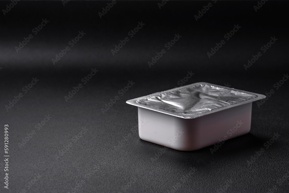 Rectangular plastic box with yogurt or cheese hermetically sealed with a foil lid Rectangular plastic box with yogurt or cheese hermetically sealed with a foil lid