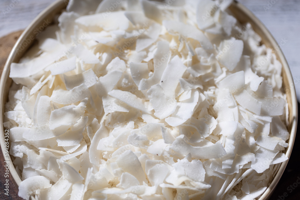 bowl of freshly shredded coconut in a beautiful bronze dish, captured from a top-down angle. visually pleasing and appetizing composition. bowl of freshly shredded coconut in a beautiful bronze dish, captured from a top-down angle. visually pleasing and appetizing composition.