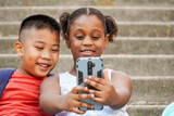 Close up of happy multiethnic children using mobile phone for vlogging. New generations of influencers on social media