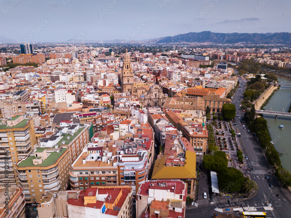 Fototapeta premium View from drone of residential areas and catholic cathedral belfry of Spanish town of Murcia on Segura river