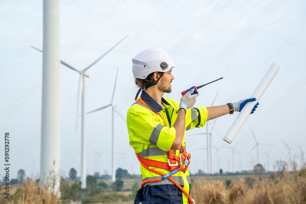 Engineer working at renewable energy farm,Inspector controlling functioning of wind turbines outdoors. Engineer working at renewable energy farm,Inspector controlling functioning of wind turbines outdoors.