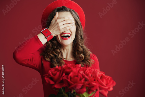 smiling modern female in red dress and beret on red background