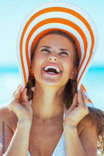 smiling young woman in hat on beach