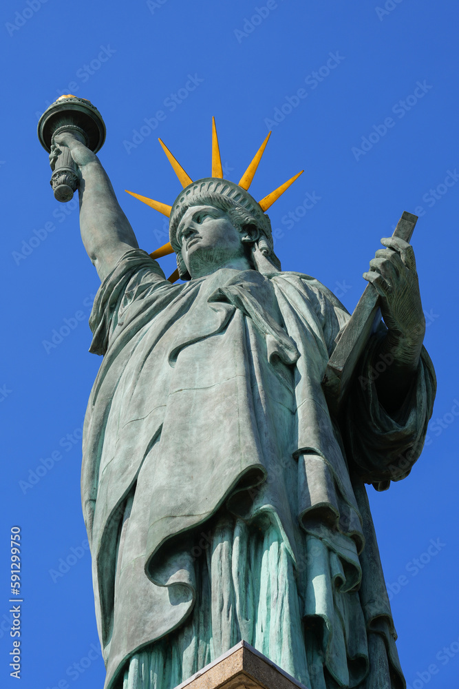Fototapeta premium Detail of the Statue of Liberty on the Island of Swans in the center of the Seine river in Paris, France - Facing west, this copper sculpture is a gift from the American community in Paris