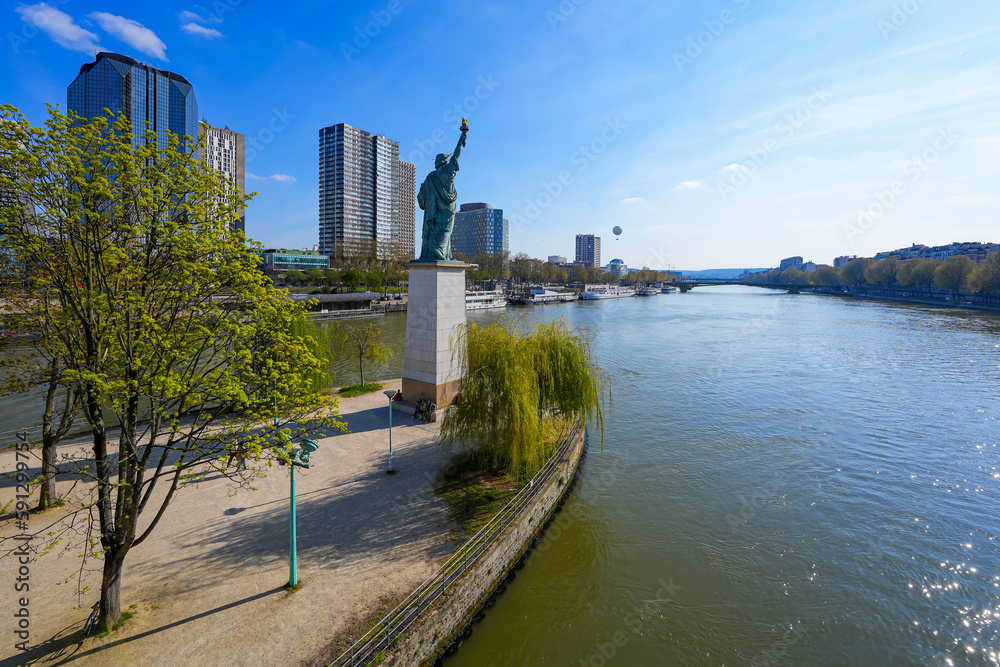 Statue of Liberty on the Island of Swans in the center of the Seine river in Paris, France - Facing west, this copper sculpture is a gift from the American community in Paris