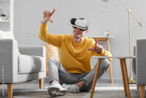 Young man using VR glasses ...
