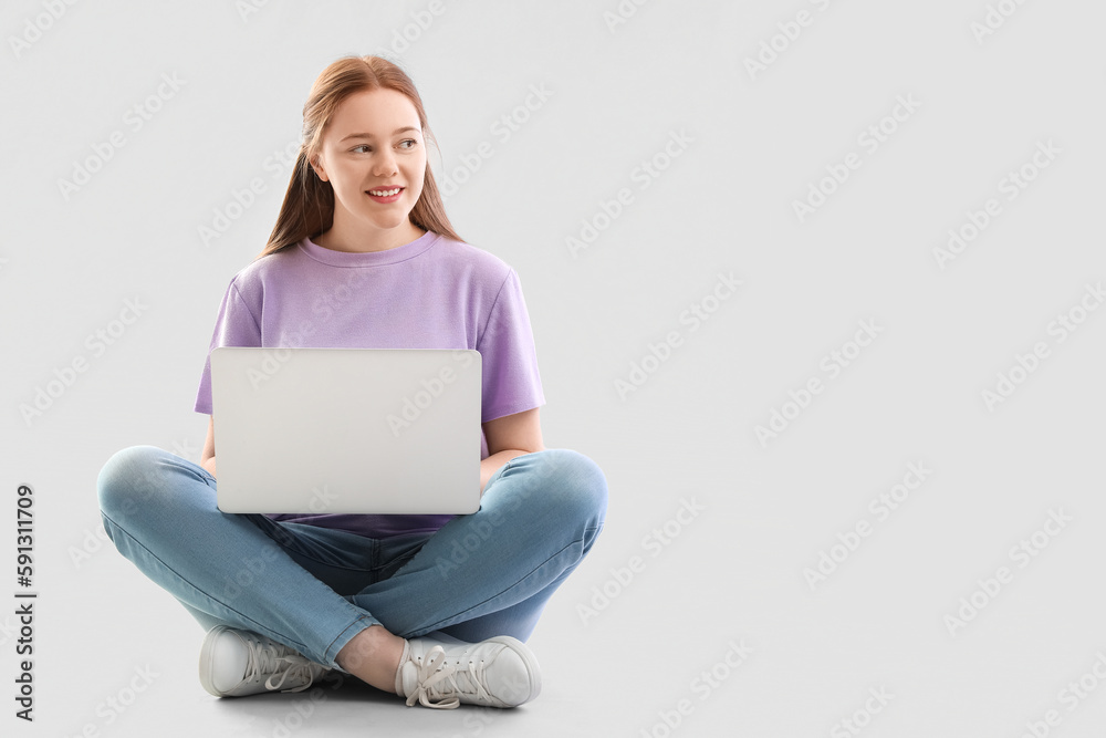 Female programmer working with laptop on light background Female programmer working with laptop on light background