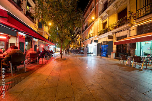 Shopping streets with restaurants at Madrid city center illuminated at night