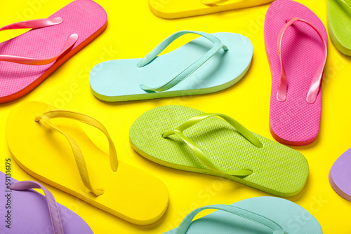 Colorful flip-flops on yellow background