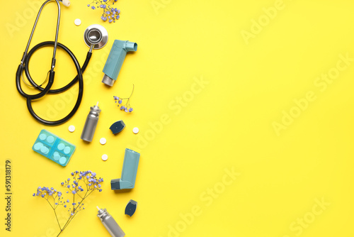 Asthma inhalers with stethoscope  pills and flowers on yellow background
