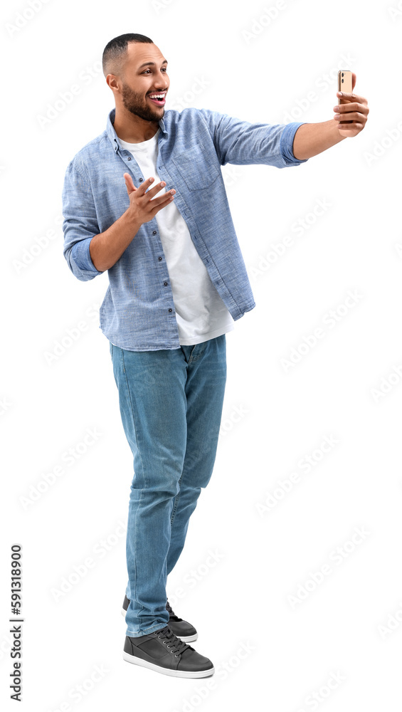 Smiling young man taking selfie with smartphone on white background