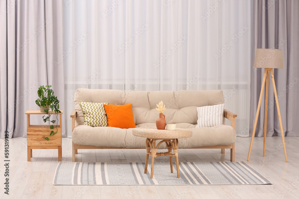 Obraz premium Comfortable sofa, coffee table and houseplant in stylish living room. Interior design