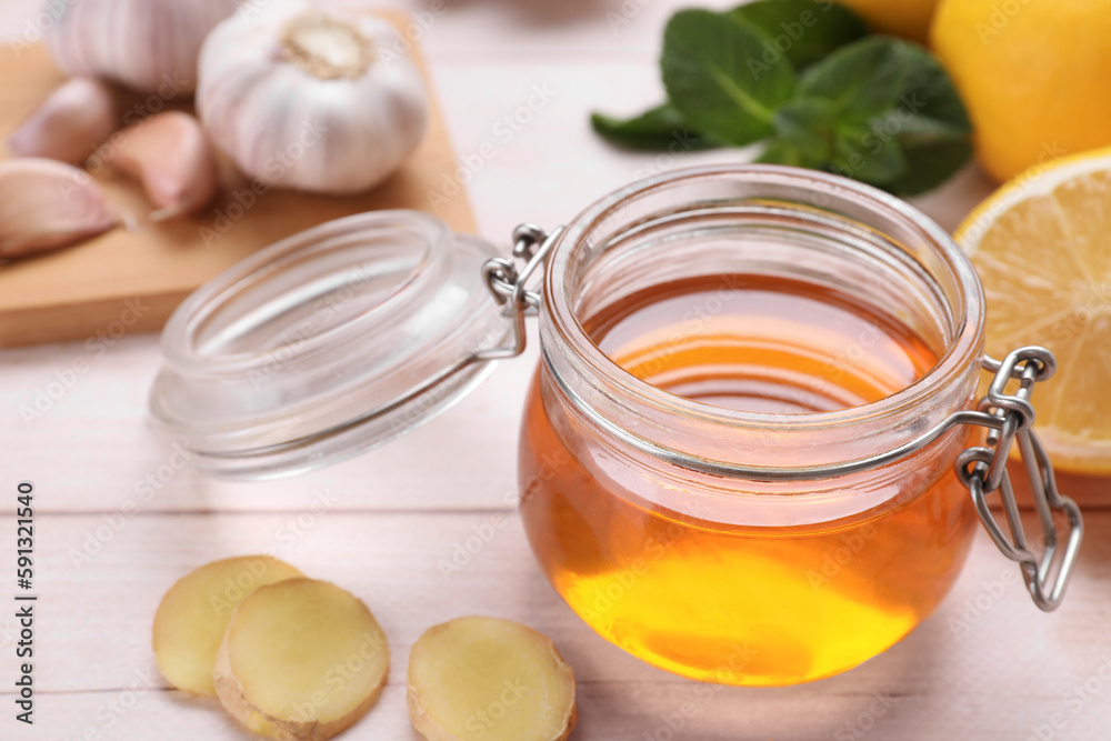 Natural cough remedies. Jar with honey and ginger on white table, closeup Natural cough remedies. Jar with honey and ginger on white table, closeup