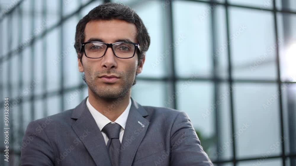 Young businessman standing in an office confidently Young businessman standing in an office confidently