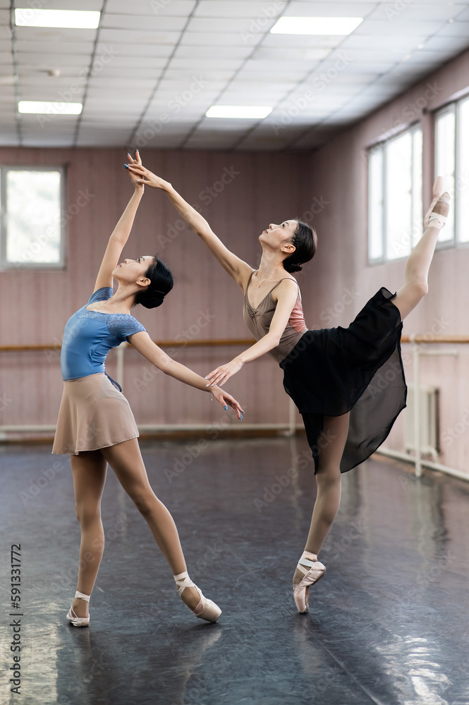 Two Asian ballerinas are dancing in the class. Two Asian ballerinas are dancing in the class.