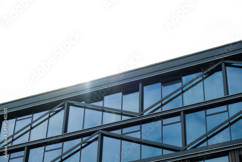 Modern glass office building exterior with glass facade on clear sky background. Transparent glass wall of office building. Element of facade of modern European building Commercial office buildings