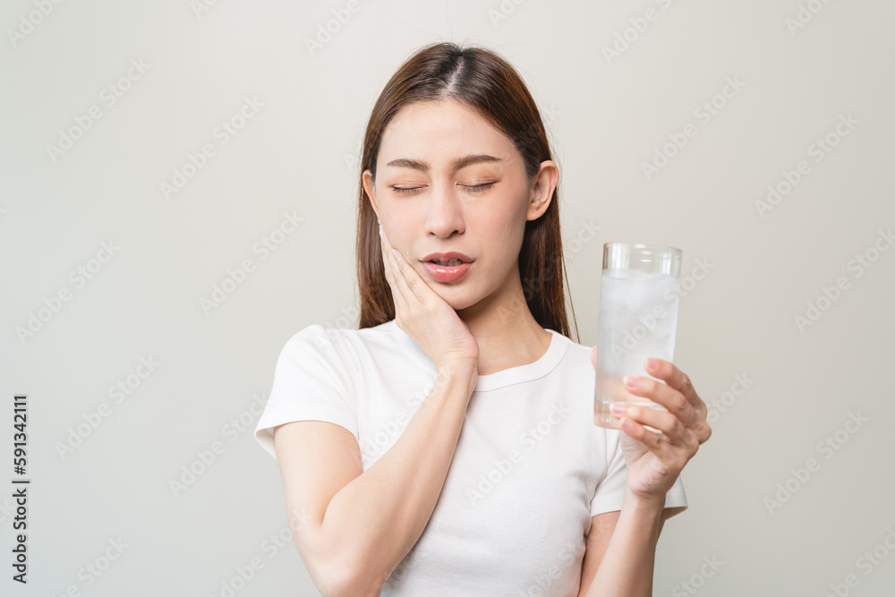 Face expression suffering from sensitive teeth, Asian young woman touching cheek