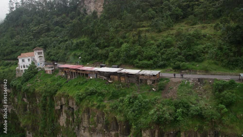 Static aerial view of ramshackle huts on tropical jungle cliff side Static aerial view of ramshackle huts on tropical jungle cliff side
