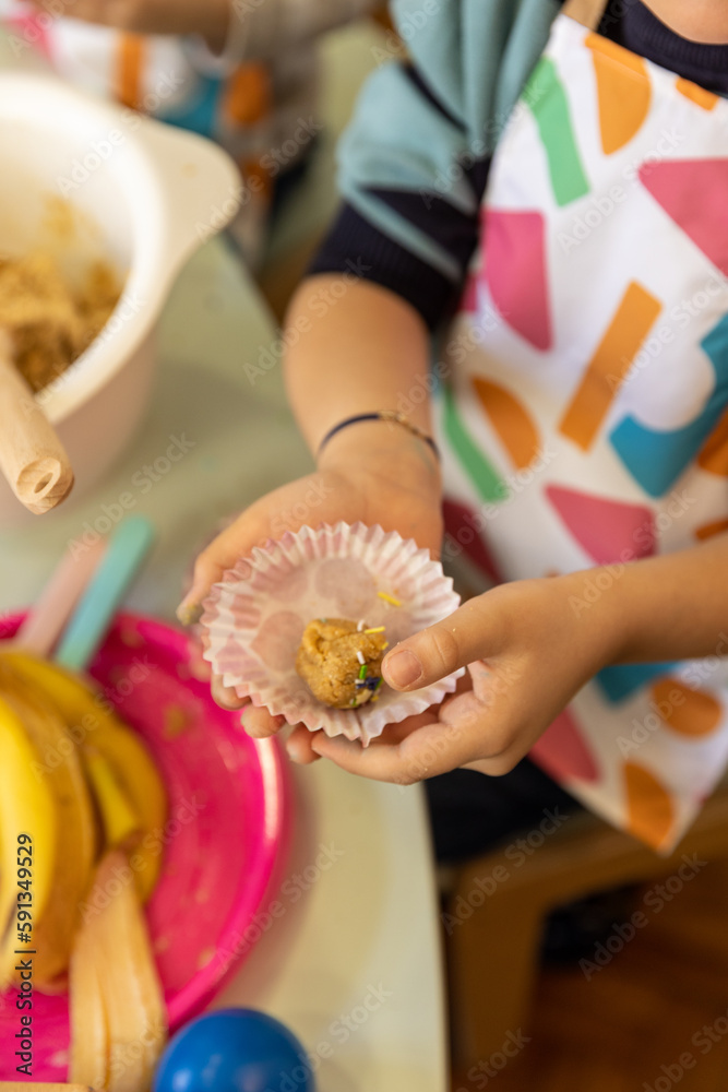 Fototapeta premium Kids prepering food in the montessori kindergarten, banana cokies