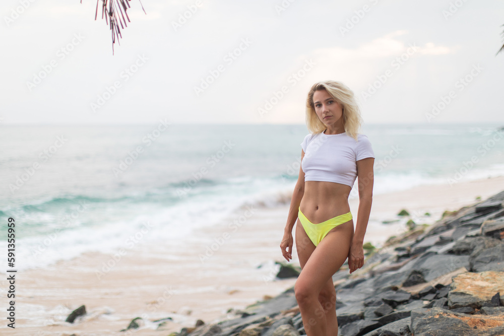 Blonde woman in a white cropped t-shirt on the ocean.